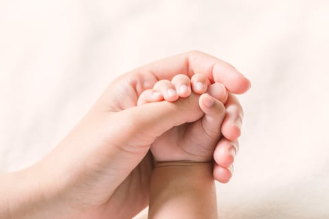 Fotografía de la mano de una madre y la mano de su bebé